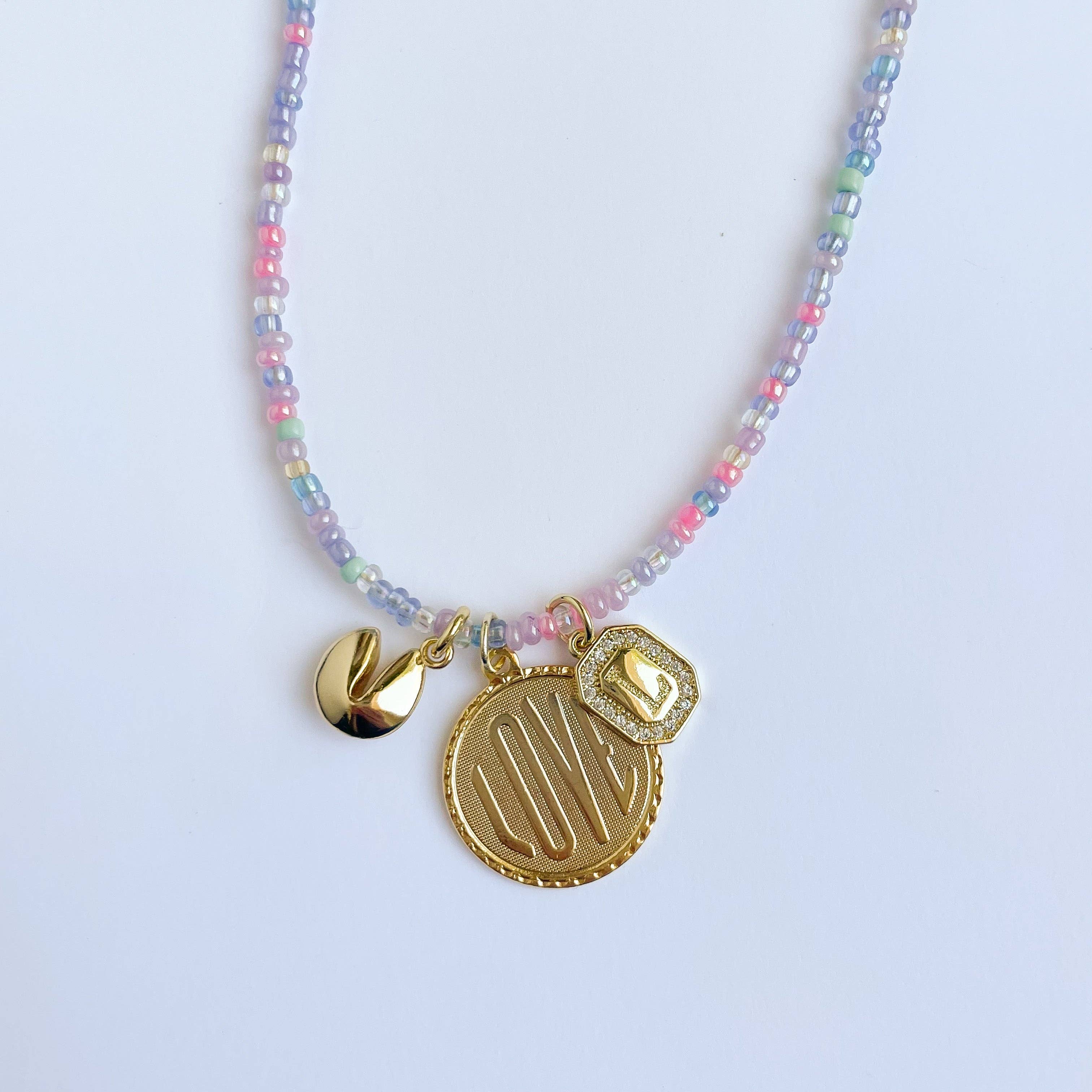 Necklace with colorful beads and gold charms on a light blue background