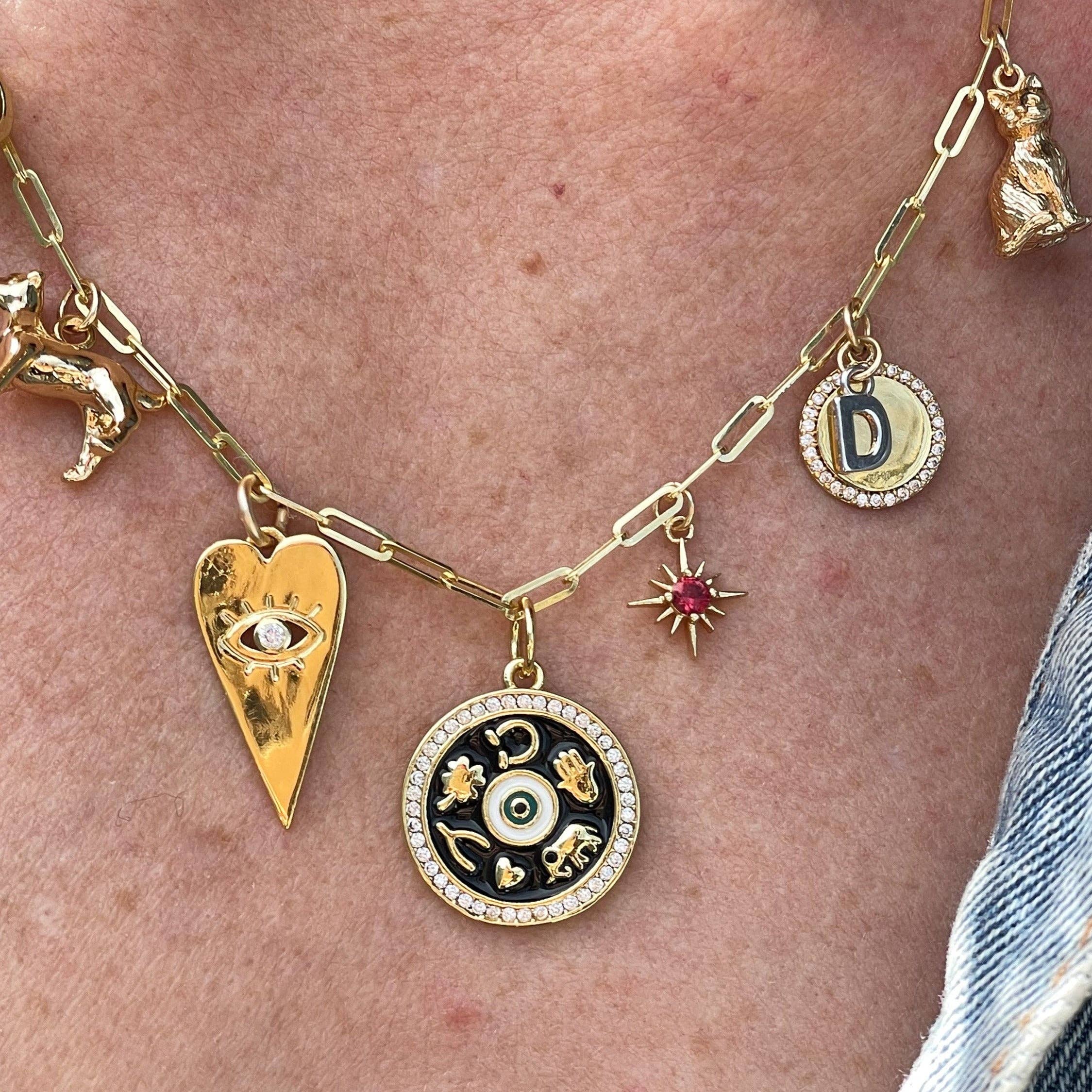 Gold necklace with various charms on a person's neck