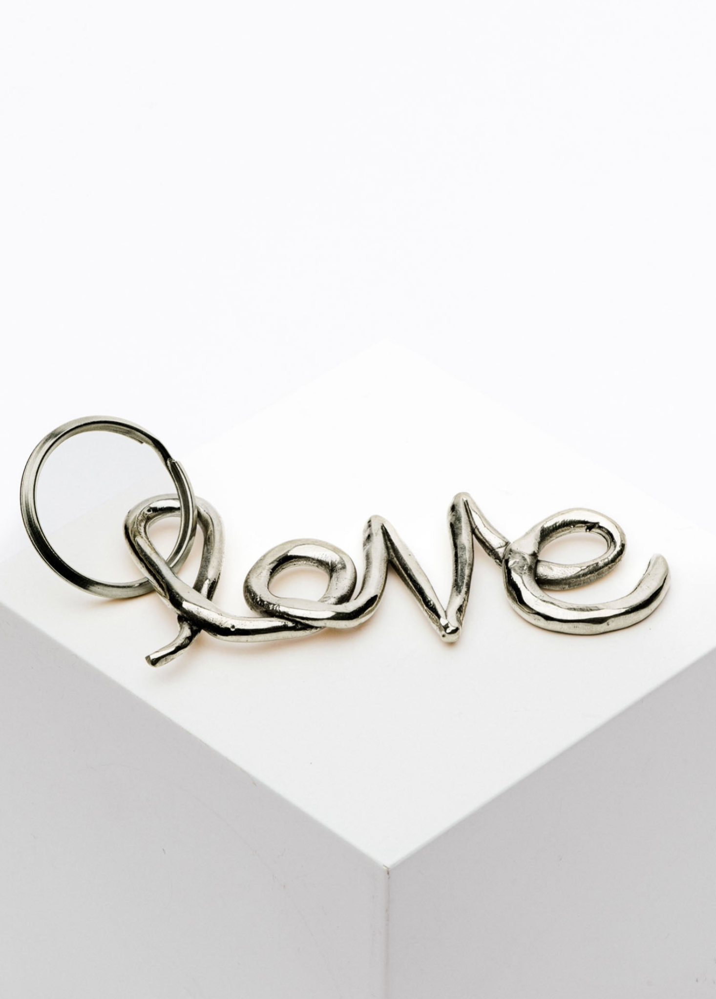 Silver 'love' charm on a white card with a gray border