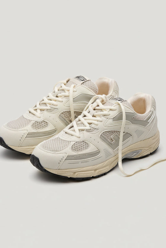 Pair of beige sneakers on a white background