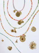 Set of beaded necklaces with various charms on a white background