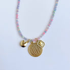 Necklace with colorful beads and gold charms on a light blue background