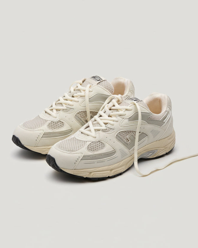Pair of beige sneakers on a white background